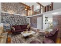 Inviting living room featuring stone accent wall, hardwood floors, and vaulted ceilings at 2014 E Broad St, Tampa, FL 33610