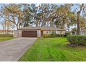 Charming single-story home featuring a well-manicured lawn, neutral exterior, and an attached two-car garage at 21918 Shamu Dr, Land O Lakes, FL 34639