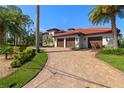 Beautiful brick driveway leads to a three-car garage with lush landscaping around the home at 2613 N Dundee St, Tampa, FL 33629