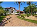 Two-story home with a brick driveway and a three-car garage, surrounded by lush landscaping at 2613 N Dundee St, Tampa, FL 33629