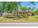 Charming bungalow featuring tan siding, brick chimney, and a detached garage with fencing at 3100 11Th N Ave, St Petersburg, FL 33713