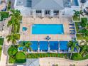 Aerial view of a sparkling outdoor pool, jacuzzi, and lounging area surrounded by lush landscaping and palm trees at 331 Cleveland St # 1202, Clearwater, FL 33755