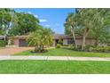 Charming single-story home with mature landscaping, brick driveway, and inviting curb appeal on a sunny day at 3320 Pattie Pl, Palm Harbor, FL 34685