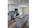 Modern kitchen featuring white cabinets, stainless steel appliances, and a granite-topped island at 4212 Pasadena Cir, Sarasota, FL 34233