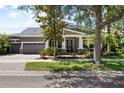 Charming home featuring a well-manicured lawn, two-car garage, and inviting front porch with classic architectural details at 5313 Sanderling Ridge Dr, Lithia, FL 33547