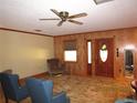Cozy living room featuring paneled walls, a ceiling fan, and a traditional patterned rug at 5602 N Dormany Rd, Plant City, FL 33565