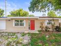 Inviting single-story home with a vibrant red door, classic windows, and a well-kept exterior at 6627 Main St, New Port Richey, FL 34653