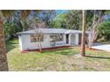 Home featuring a freshly painted exterior, manicured landscaping, and an attached one-car garage with an arched entryway at 7926 Gulf Way, Hudson, FL 34667