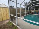 A fenced pool area is shown, surrounded by new wood fence and screen enclosure, perfect for privacy and outdoor enjoyment at 9818 White Barn Way, Riverview, FL 33569