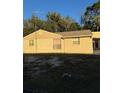 A single story home with neutral siding and visible windows, surrounded by a sparse lawn at 9900 Ideal Ln, Hudson, FL 34667