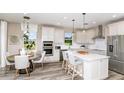Bright and airy kitchen with white cabinets, stainless steel appliances, and island seating at 9970 Trellis Vine Way, Parrish, FL 34219