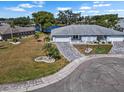 Expansive aerial view of the home featuring a paver driveway, beautiful landscaping, and a serene lake view at 1002 Strawpocket Pl, Sun City Center, FL 33573