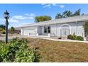 Well-maintained one-story home featuring light gray stucco, an arched entryway, and attractive landscaping at 1002 Strawpocket Pl, Sun City Center, FL 33573