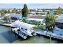 Beautiful waterfront home featuring a private boat lift, lush landscaping, and serene water views at 1015 Spindle Palm Way, Apollo Beach, FL 33572