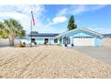 Charming coastal home with an attached garage, solar panels, palm trees, and gravel landscaping at 1015 Spindle Palm Way, Apollo Beach, FL 33572