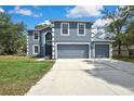 Gray two-story home highlighting white trim, a well-kept lawn, and a concrete driveway with an attached two-car garage at 11257 Persimmon Ave, Weeki Wachee, FL 34614