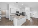 Bright kitchen featuring an island, stainless steel appliances, granite countertops, and modern fixtures at 124 Hallam Ct, Spring Hill, FL 34606