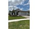 Charming single-story home featuring a well-manicured lawn, stone driveway, and neutral color scheme at 17122 Moonflower Dr, Venice, FL 34293