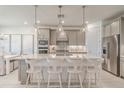 Modern kitchen with stainless steel appliances, central island, pendant lighting and breakfast bar at 17146 Moonflower Dr, Venice, FL 34293