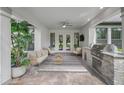 Outdoor patio with an outdoor kitchen, grill, stone detail, seating, and views of the backyard at 17466 Nokota Ave, Hudson, FL 34667