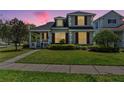 Charming two-story home at dusk with red window shutters and manicured lawn at 20053 Heritage Point Dr, Tampa, FL 33647