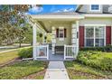 Charming front porch with decorative columns, bench seating, and well-maintained landscaping at 20053 Heritage Point Dr, Tampa, FL 33647