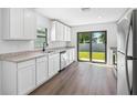 Modern kitchen with white cabinets, stainless steel appliances and sliding glass door to the backyard at 2024 Waterfall Dr, Spring Hill, FL 34608