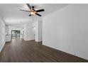 Open-concept living room featuring hardwood floors, ceiling fan and natural light at 2024 Waterfall Dr, Spring Hill, FL 34608