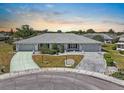 An aerial view of a home with a well-manicured lawn and a paved driveway at 204 Cactusflower Ln, Sun City Center, FL 33573
