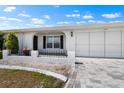 A home with a two-car garage, beautiful landscaping, and a paved walkway to the front door at 204 Cactusflower Ln, Sun City Center, FL 33573