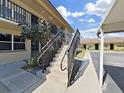 Exterior view featuring concrete stairs leading to the second-story units, framed by black iron railings at 2501 Harn Blvd # H39, Clearwater, FL 33764