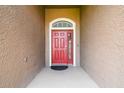 Welcoming front door showcasing red door and stylish exterior for a great curb appeal at 2611 Eagle Crest Ct, Holiday, FL 34691
