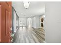 Bright and airy living space featuring hardwood floors, neutral walls, and arched doorway at 2611 Eagle Crest Ct, Holiday, FL 34691