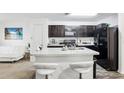 Modern kitchen with white countertops, dark cabinets and stainless-steel appliances at 26377 Bertram Rd, Brooksville, FL 34602