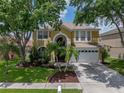Charming two-story home featuring lush landscaping and a well-maintained front yard at 27231 Liriope Ct, Wesley Chapel, FL 33544
