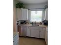 Well-lit kitchen featuring stainless steel appliances and white cabinetry at 361 Fairhaven St, Port Charlotte, FL 33952