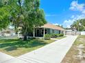 Charming one-story home with a long driveway, lush lawn, and inviting front porch at 425 E Orange St, Tarpon Springs, FL 34689