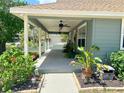 Charming home exterior with a large front porch, lush plants, and updated landscaping at 425 E Orange St, Tarpon Springs, FL 34689