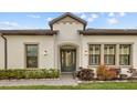 Home exterior displaying covered front entrance with dark trim windows and neutral paint at 4354 Barletta Ct, Wesley Chapel, FL 33543