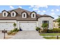 Home exterior displaying a three car garage and driveway with manicured landscaping at 4354 Barletta Ct, Wesley Chapel, FL 33543