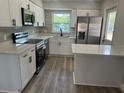 Modern kitchen featuring stainless steel appliances, quartz countertops and wood grain vinyl floors at 613 Coronet St, Plant City, FL 33563