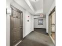 Well-lit hallway with neutral carpet and wall art, leading to apartment doors and an exit at 700 S Harbour Island Blvd # 740, Tampa, FL 33602