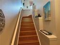 Stairway with hardwood floors leading upwards to the second floor featuring decorative shelving and a white banister at 716 Seagate Dr # 716, Tampa, FL 33602