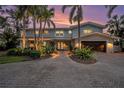 Beautiful two-story home with lush landscaping, a brick driveway, and a two-car garage surrounded by tall palm trees at 8488 35Th N Ave, St Petersburg, FL 33710
