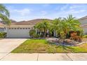 Well-maintained home with a two-car garage and lush landscaping at 9632 Asbel Estates St, Land O Lakes, FL 34638