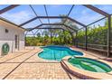 Relaxing screened-in pool and hot tub with brick patio at 9632 Asbel Estates St, Land O Lakes, FL 34638