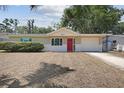 Charming single-story home featuring a red front door and well-maintained landscaping at 10817 Kingsbridge Rd, Port Richey, FL 34668