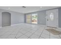 Bright living room featuring white tile flooring, recessed lighting, and a view of the front porch at 1170 Chelsea Ln, Holiday, FL 34691