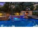 A beautiful in-ground pool features fire bowls, custom tile, and an outdoor pizza oven at 11804 Carrollwood Village Cv, Tampa, FL 33618