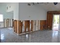 View of the Living Room needing repair showing bare studs and tile flooring at 119 18Th Nw St, Ruskin, FL 33570